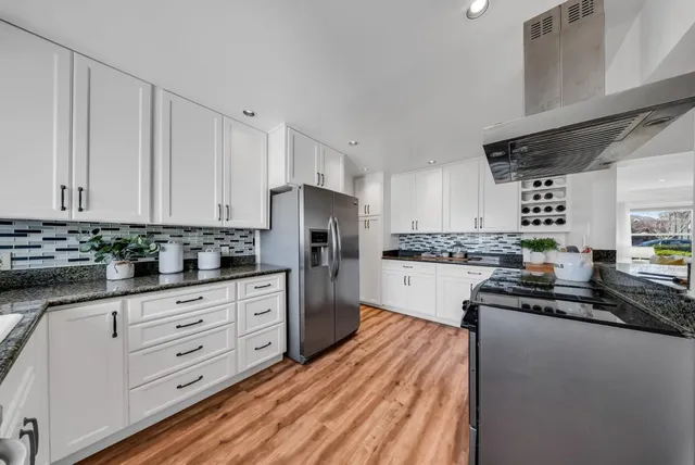 a kitchen with granite countertop white cabinets and white appliances