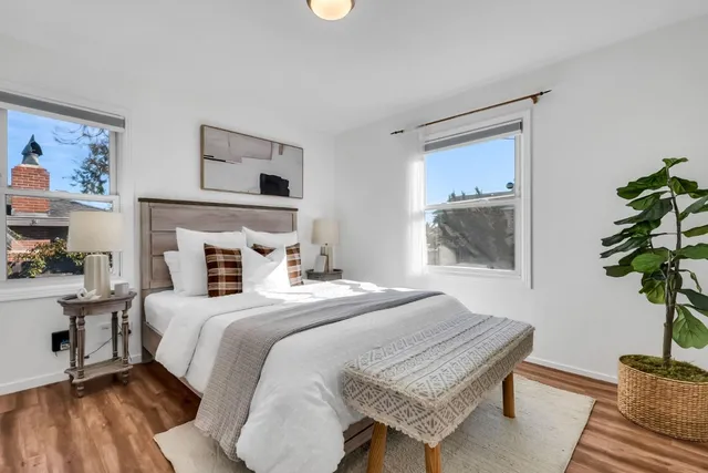 a bedroom with a bed and a potted plant