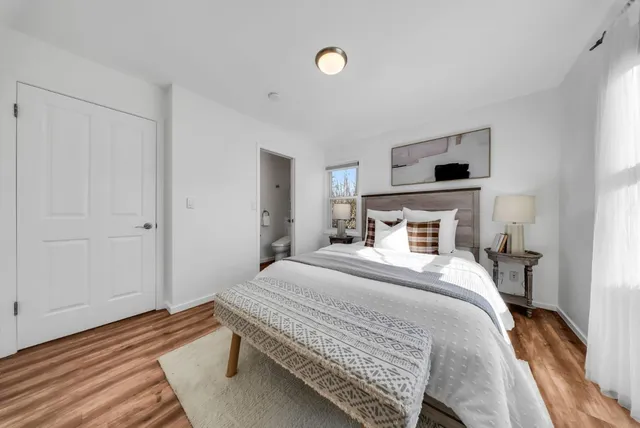 a bedroom with a bed and wooden floor