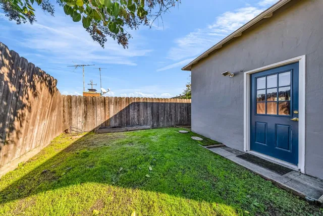 a view of backyard with potted plants and wooden fence