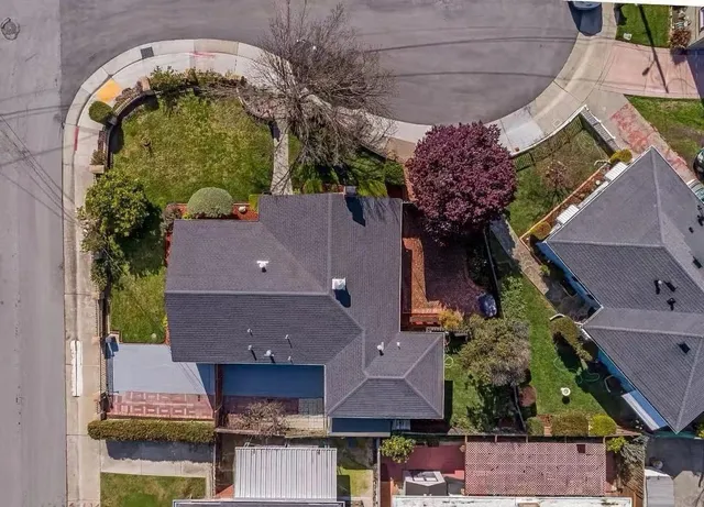 an aerial view of a house with a yard and a fountain
