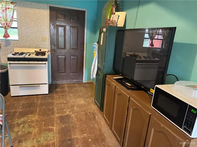 a kitchen with stainless steel appliances a stove microwave and refrigerator