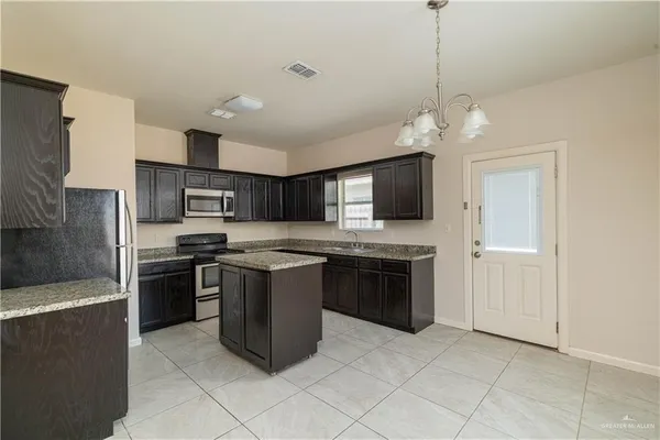 a large kitchen with stainless steel appliances granite countertop a stove and a sink