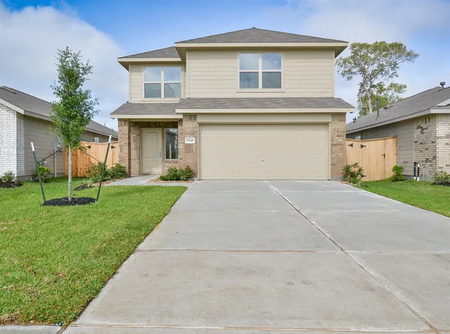 a front view of a house with a yard and trees