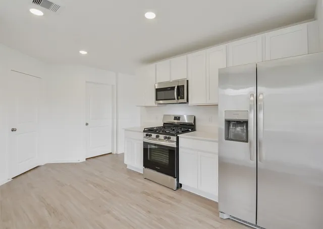 a kitchen with a refrigerator stove and microwave