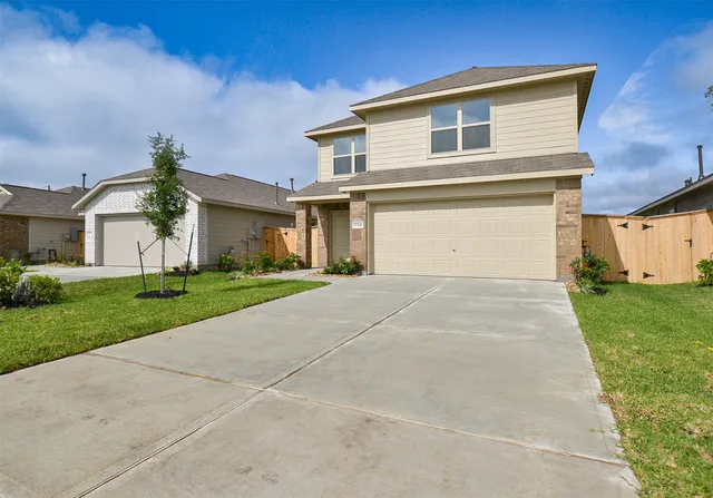 a front view of a house with a yard and garage