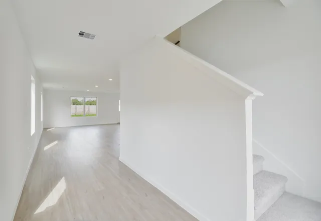 a view of a hallway with wooden floor