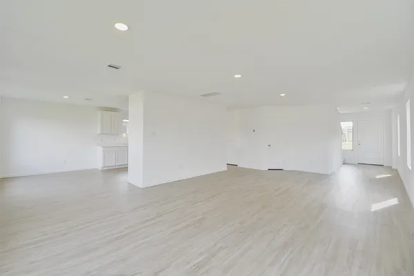 a view of empty room with wooden floor and windows