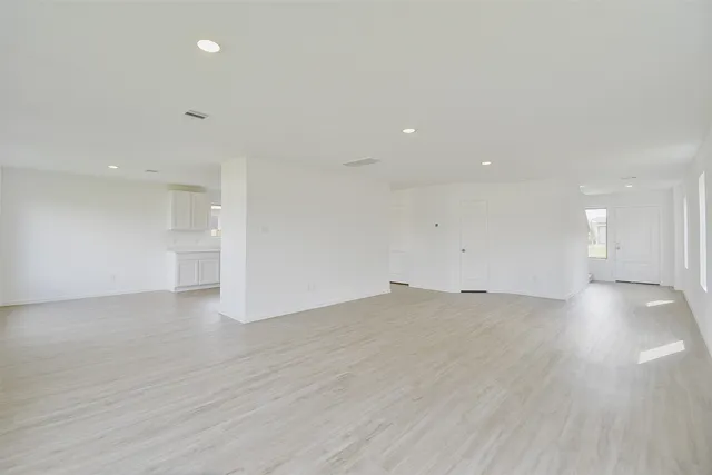 a view of empty room with wooden floor and windows