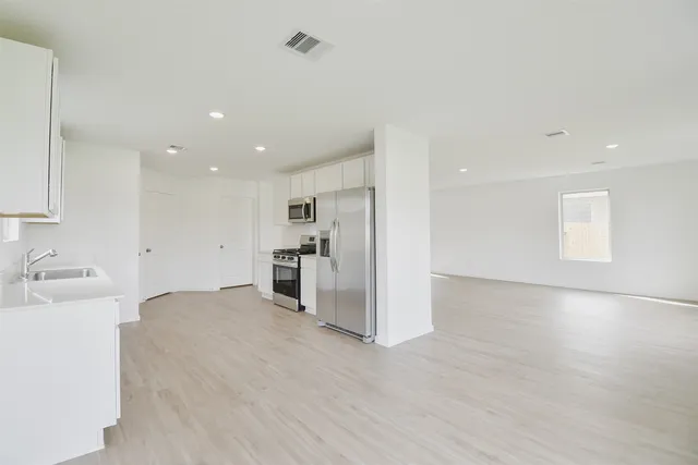 a view of a kitchen with a sink and a refrigerator