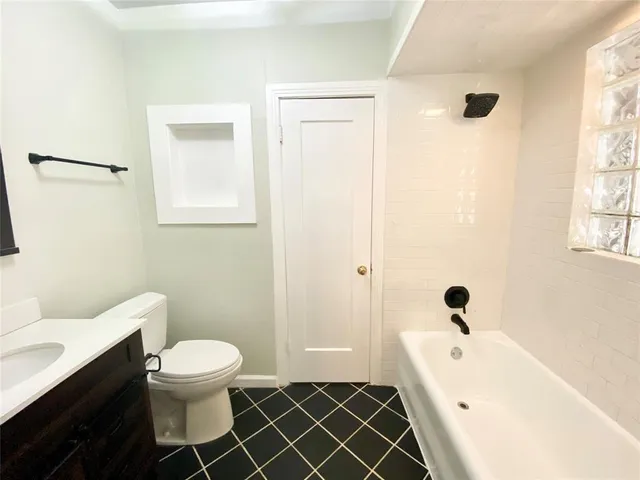 a white toilet sitting next to a bathroom sink and tub