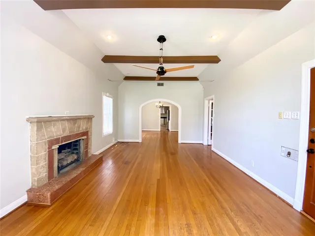 a view of a livingroom with wooden floor and a fireplace