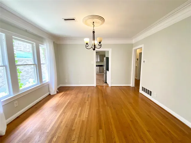 a view of empty room with wooden floor and window