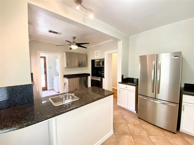 a kitchen with stainless steel appliances granite countertop a refrigerator and a sink