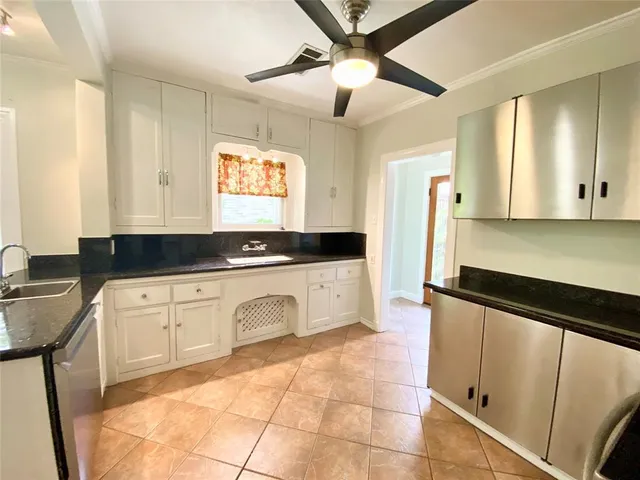 a kitchen with granite countertop white cabinets white appliances with a sink and a large mirror