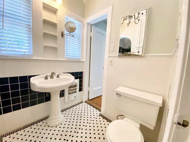 a bathroom with a sink toilet and mirror