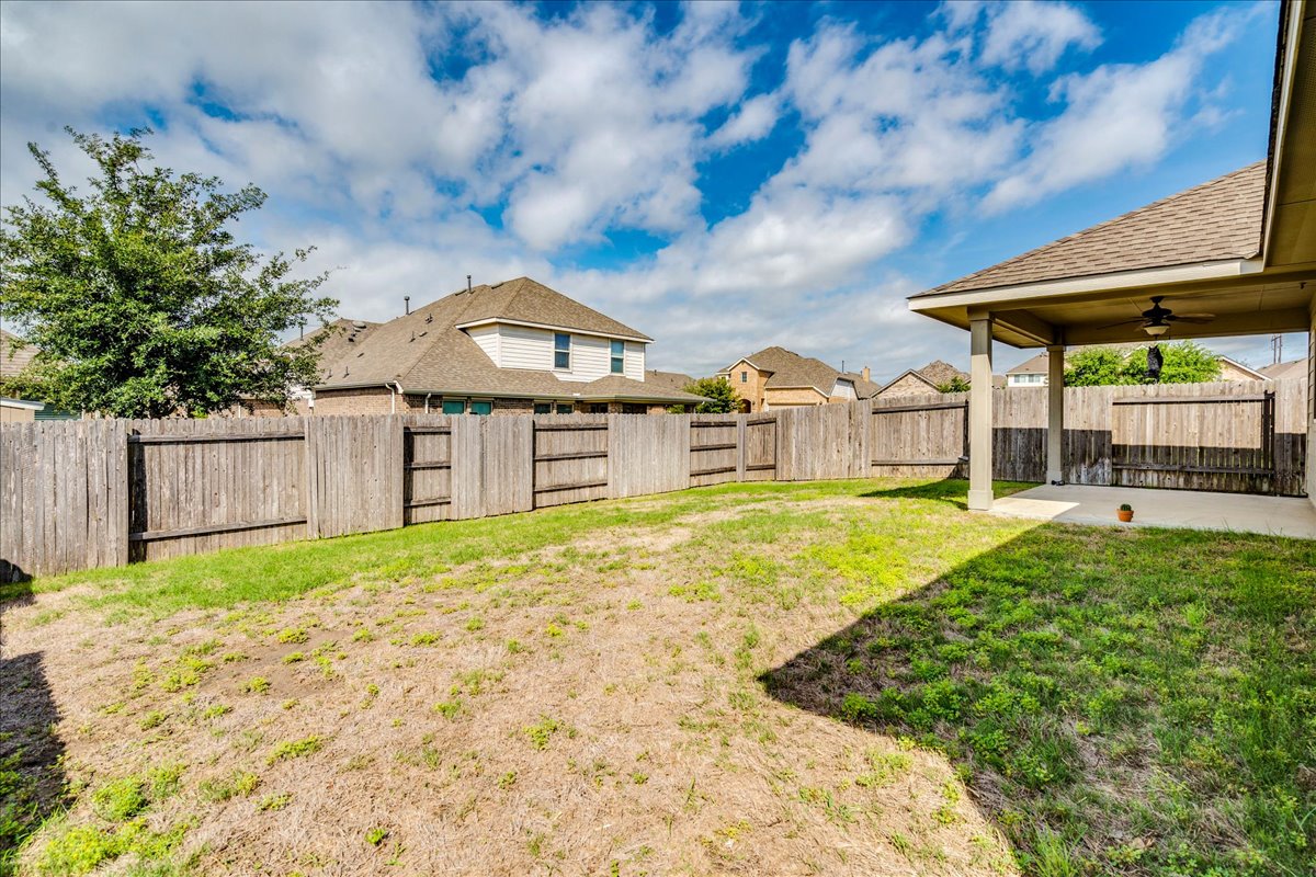 124 Compass Lane Kyle, TX 78640 - Photo 34 of 38 a front view of a house with a yard table and chairs