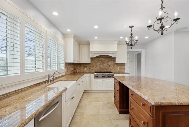 a open kitchen with granite countertop a sink stove and cabinets