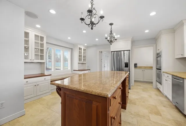 a kitchen with kitchen island a sink stainless steel appliances and cabinets