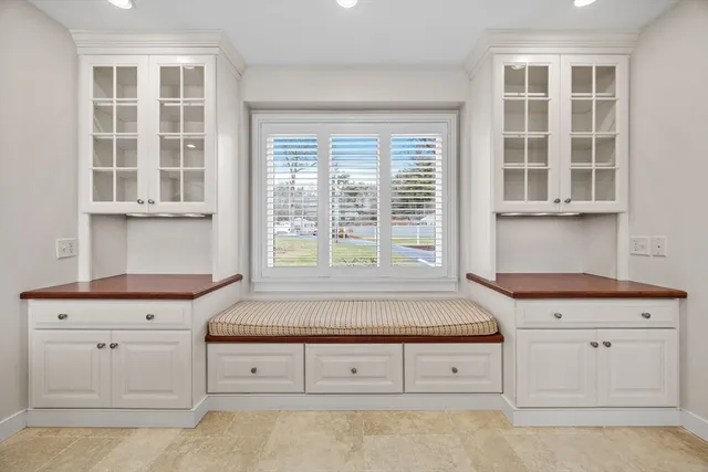 a kitchen with granite countertop white cabinets and window