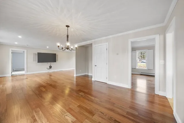 a view of a livingroom with a flat screen tv wooden floor and a ceiling fan