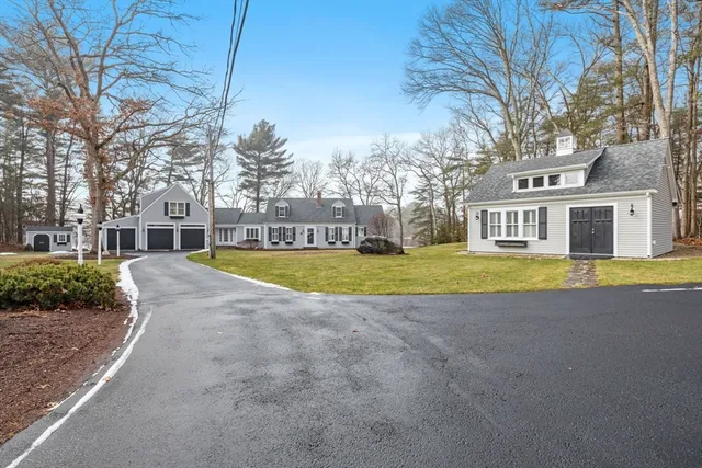 a view of a house with a big yard and large trees