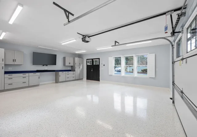 a view of an empty room with a window and kitchen view