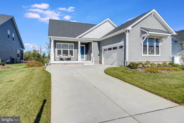 a front view of a house with a garden and yard