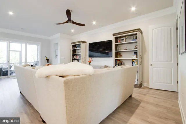 a kitchen with kitchen island a dining table chairs sink and white cabinets