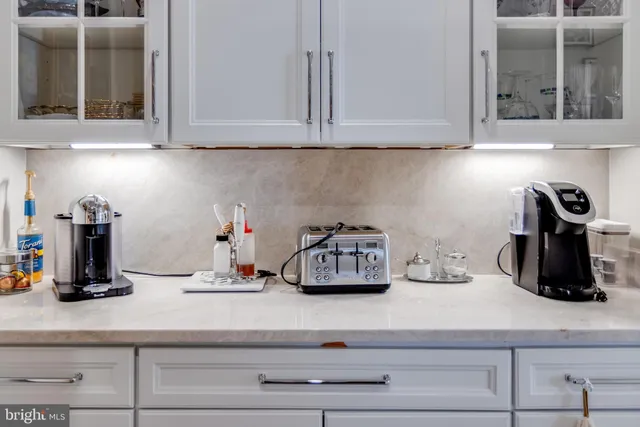 a bed sitting in a bedroom with a white comforter and pillows