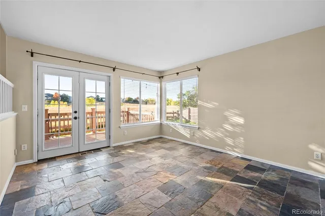 a view of an empty room with glass door and windows