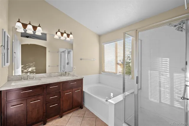 a spacious bathroom with a tub sink and mirror