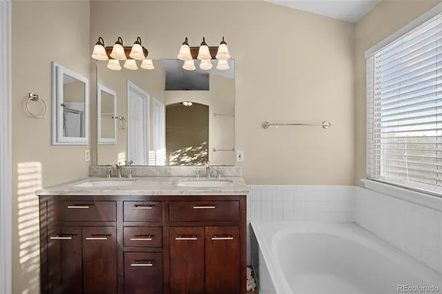 a bathroom with a tub sink and mirror
