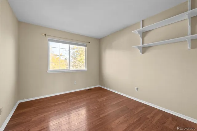 a view of a room with wooden floor and windows