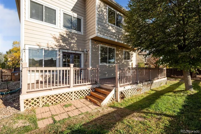 a view of a house with a small yard and wooden fence