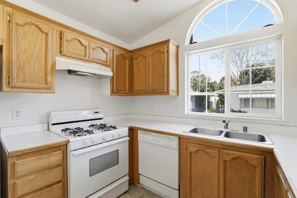 a kitchen with stainless steel appliances granite countertop a sink stove and cabinets