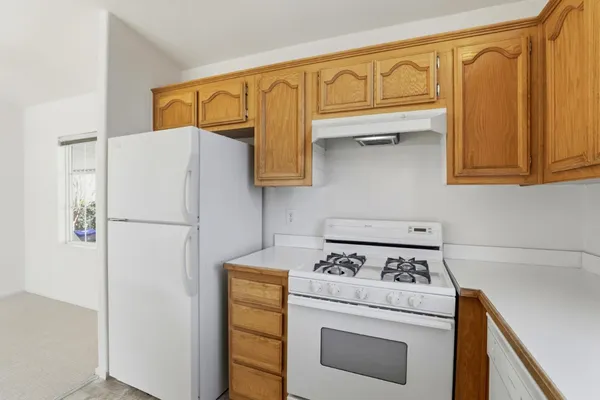 a white refrigerator freezer and a stove sitting inside of a kitchen