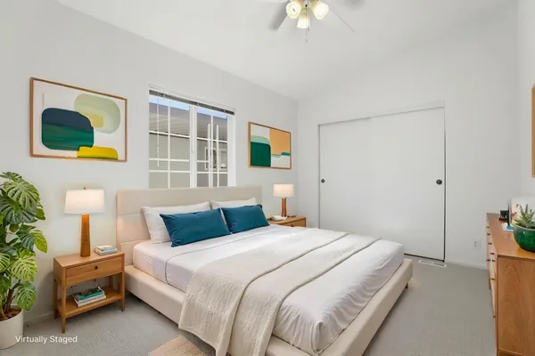 a bedroom with a bed and a potted plant
