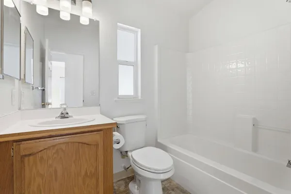 a bathroom with a sink toilet vanity and tub