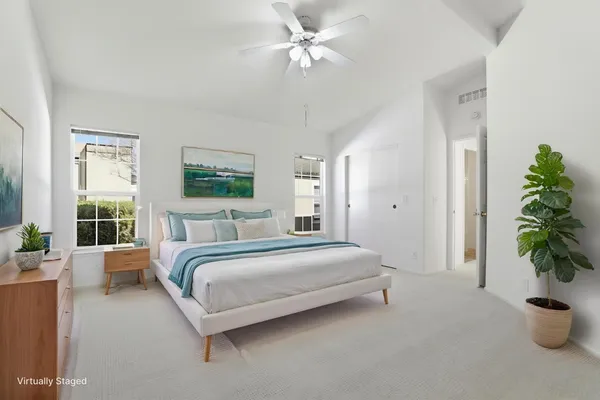 a spacious bedroom with a large bed and a potted plant