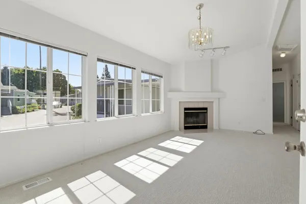 a view of an empty room with a fireplace and a window