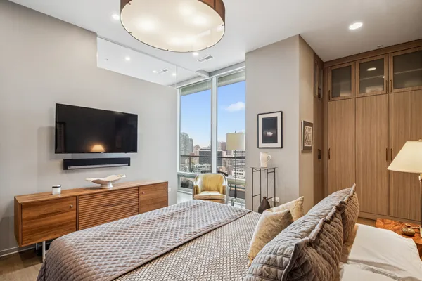 a bedroom with furniture and a flat screen tv