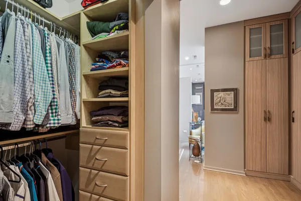 a view of walk in closet with clothes and shoes
