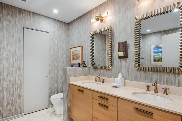 a bathroom with a toilet a sink a mirror and vanity