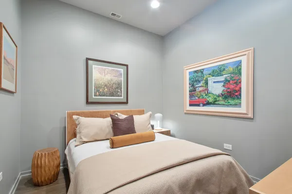 a bedroom with a bed and a painting on the wall