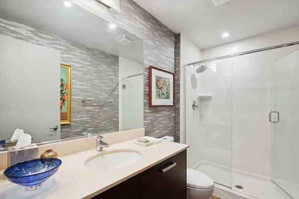 a bathroom with a sink a toilet and shower