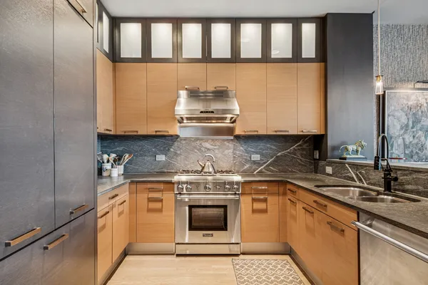 a kitchen with granite countertop a stove sink and cabinets