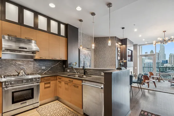 a kitchen with stainless steel appliances granite countertop a stove a sink and a refrigerator