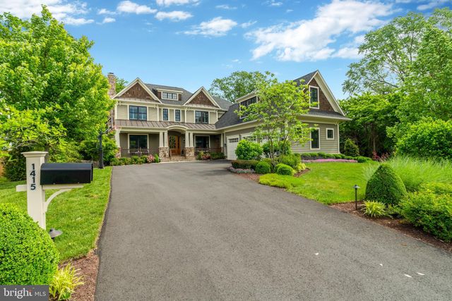 a front view of a house with a yard and potted plants