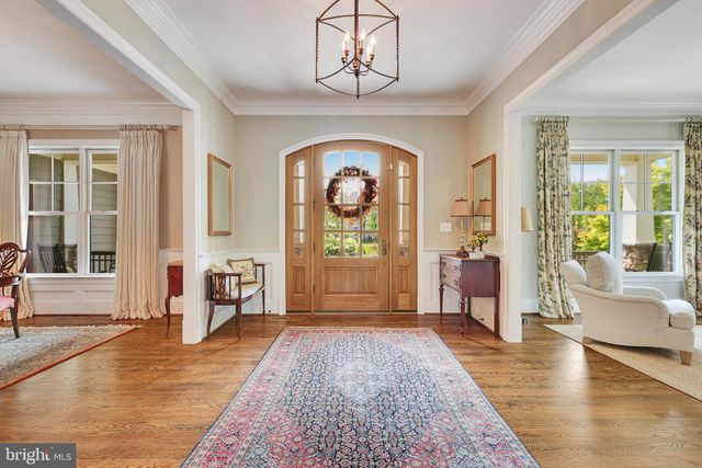 a living room with furniture and a large mirror next to a window